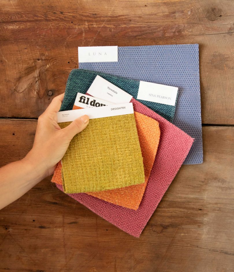 layered stack of folded fabrics on wood table