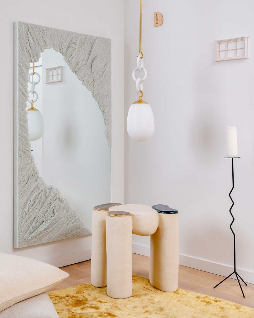 styled living space with wall art, modern stool, and suspended lighting