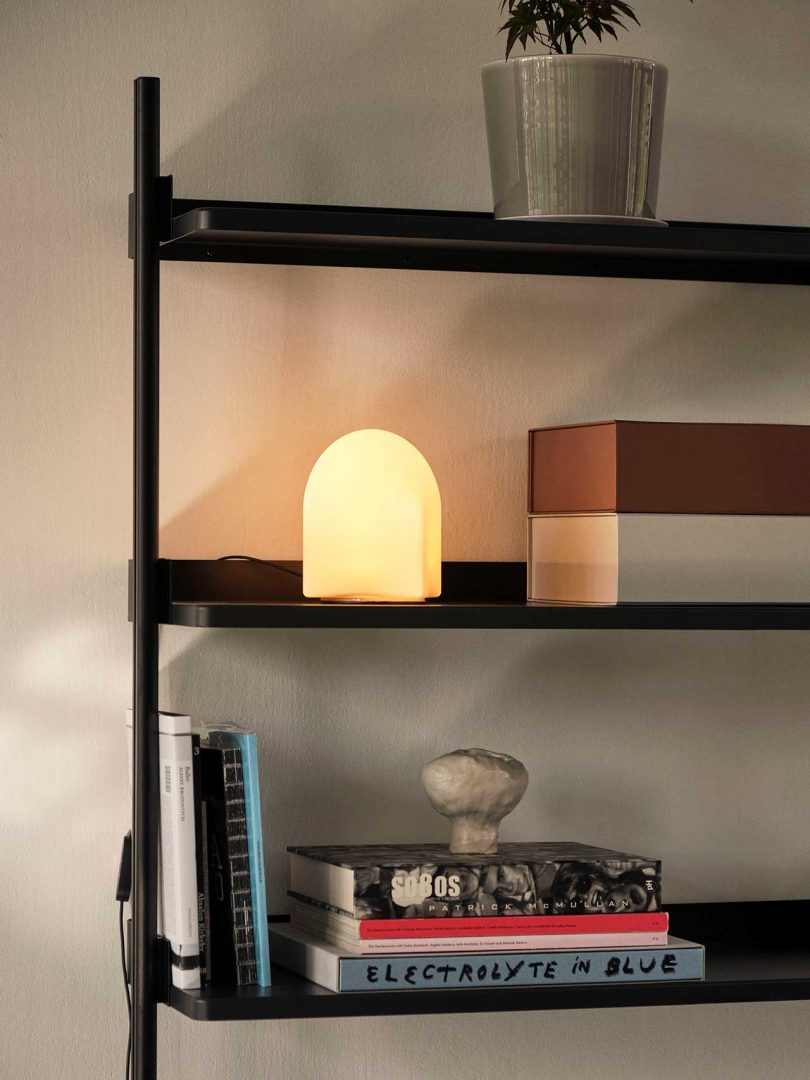 lit table lamp on shelves
