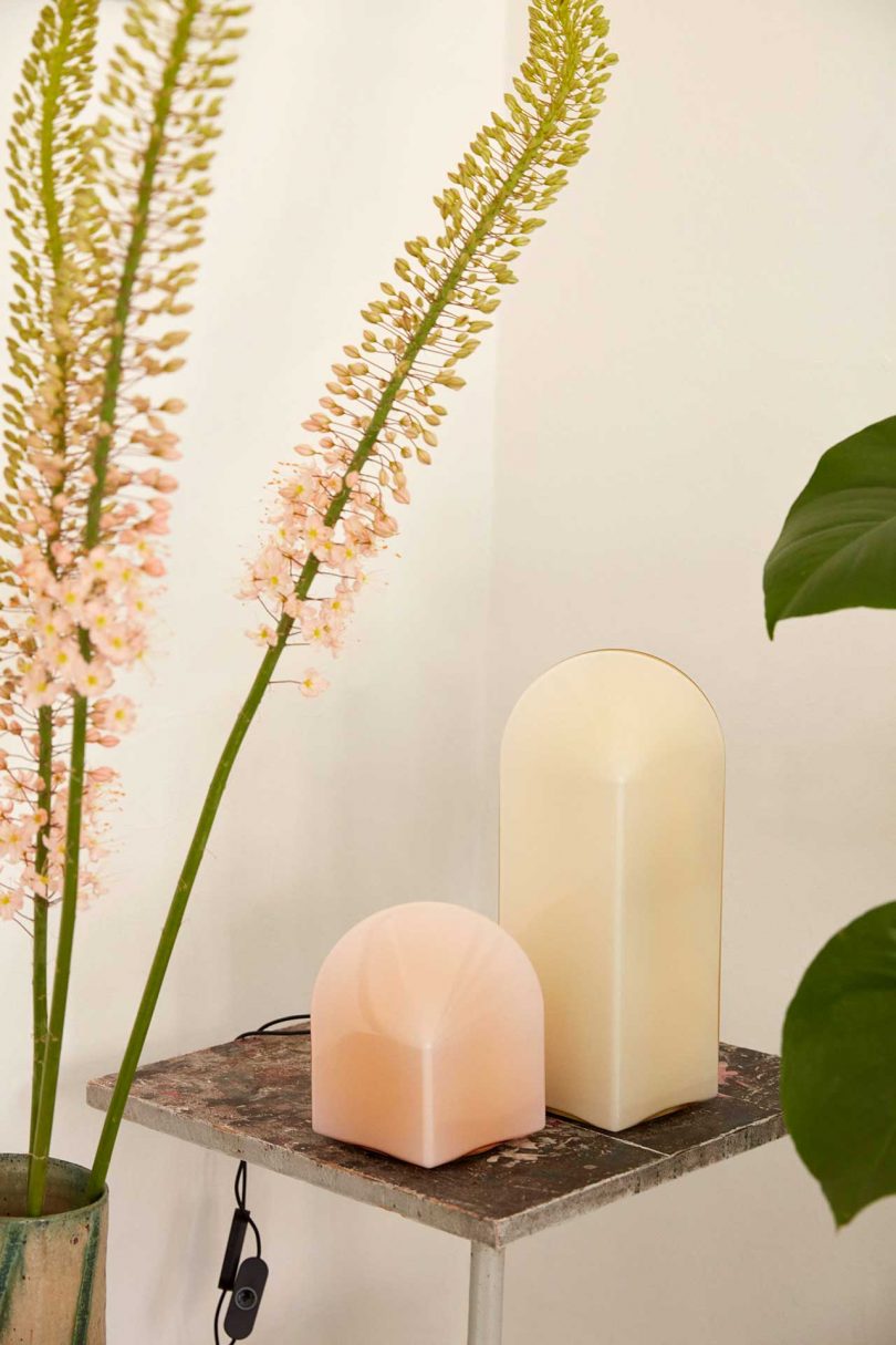 one pink and one white table lamp of varying heights