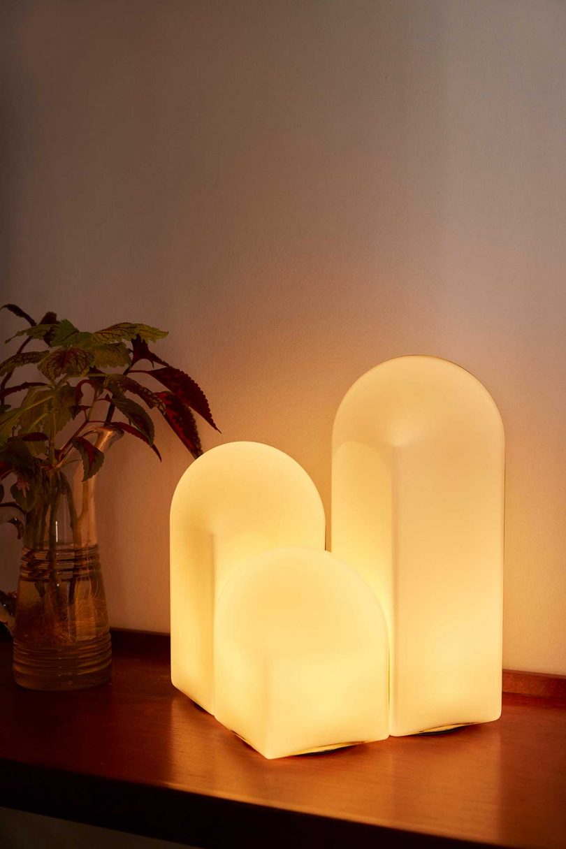 three lit white table lamps of varying heights