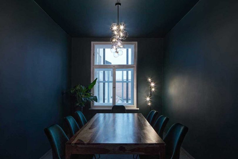 conference room in modern office with deep blue walls and wood furniture