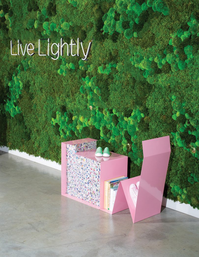 piece of pink sculptural furniture against a wall of greenery