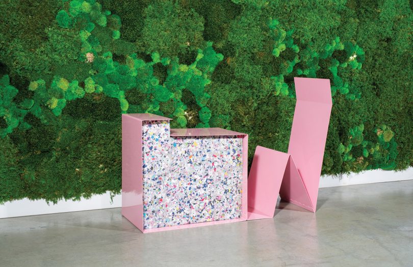 piece of pink sculptural furniture against a wall of greenery