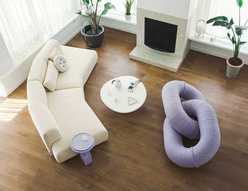 abstract lavender sofa and curved white sofa in a styled living space