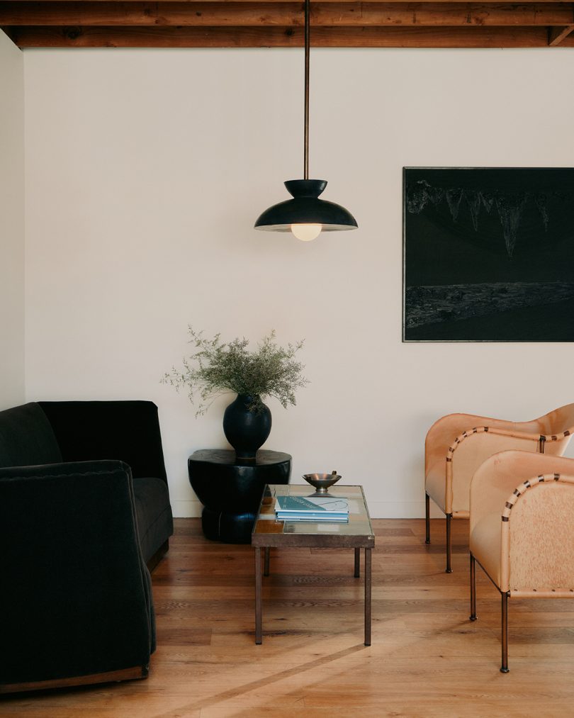 dark pendant lamp hanging in a styled living space