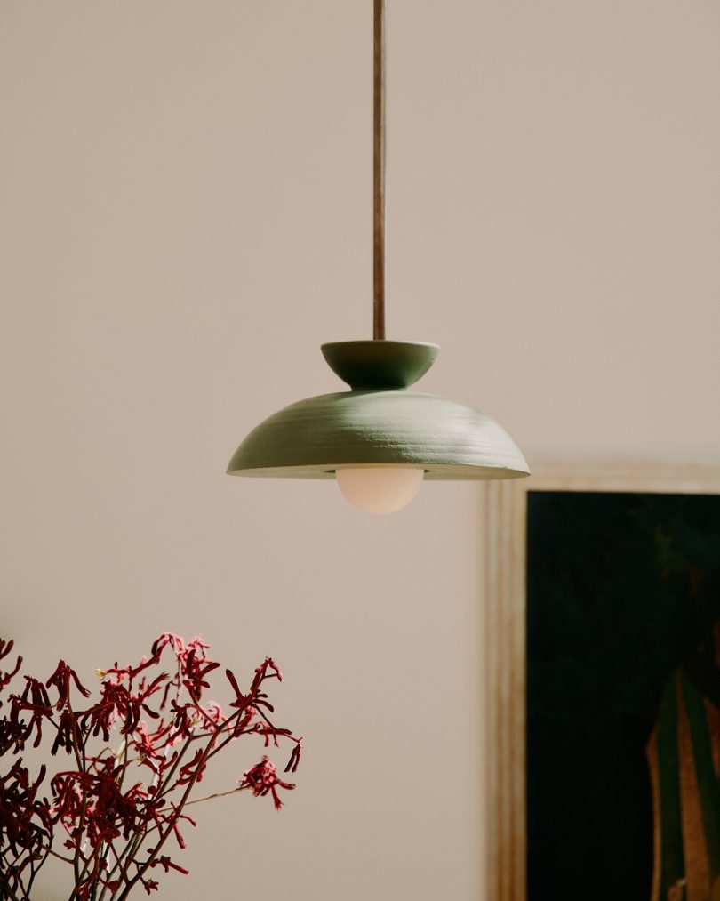 dark pendant lamp hanging in a styled living space