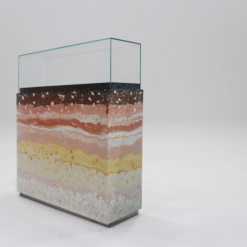 glass square container holding layers of gradient terrazzo material