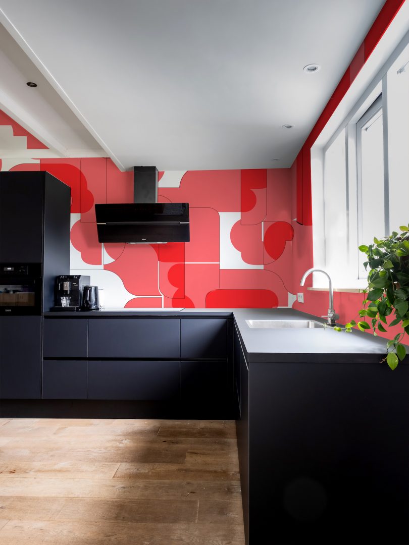 black kitchen with red wallpaper