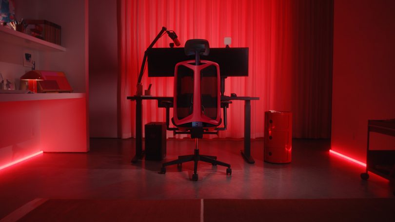 red lit gaming setup with desk and herman miller chair