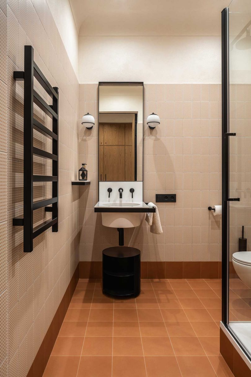 modern bathroom with peach colored tile walls and persimmon tile floors