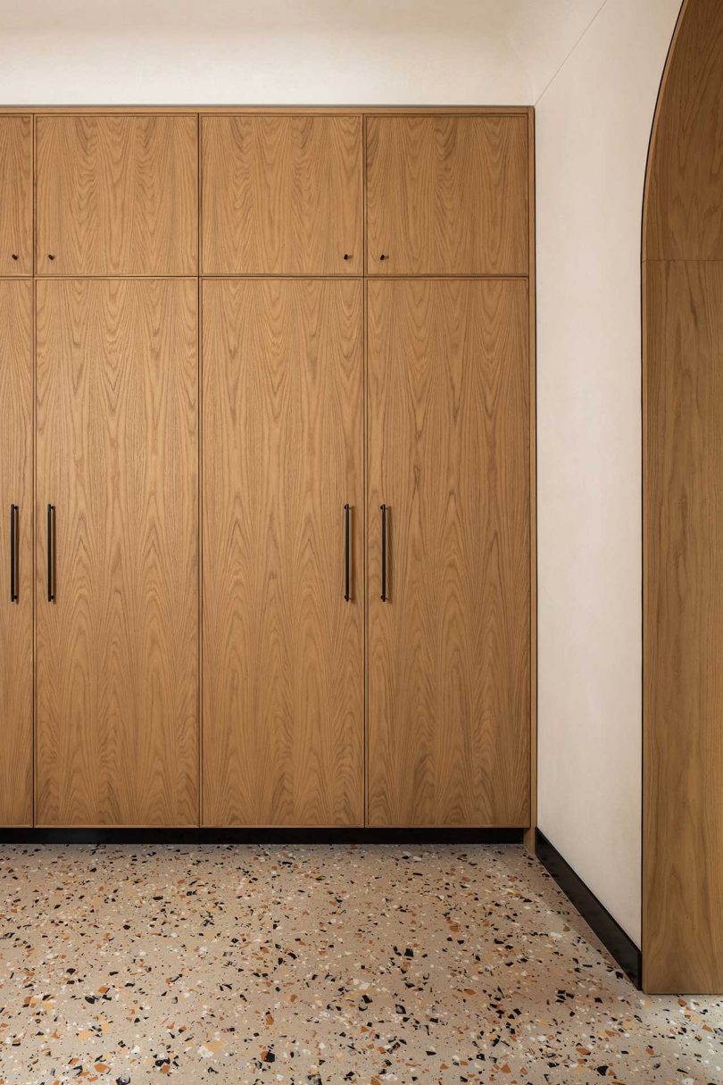 bank of built-in wood cabinets and terrazzo floors