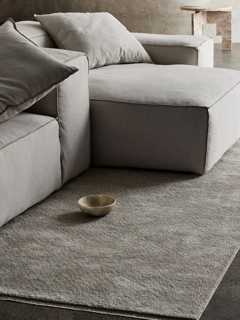 detail of neutral tone floor rug and upholstered furniture