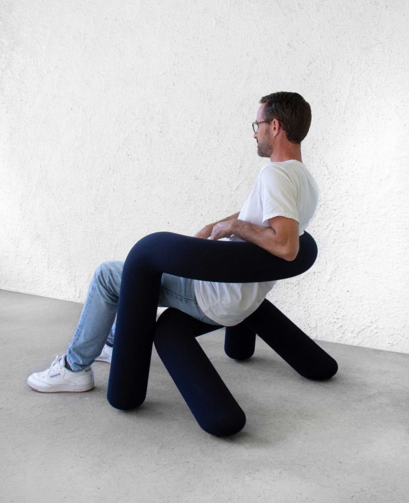 man sitting on navy blue tube chair