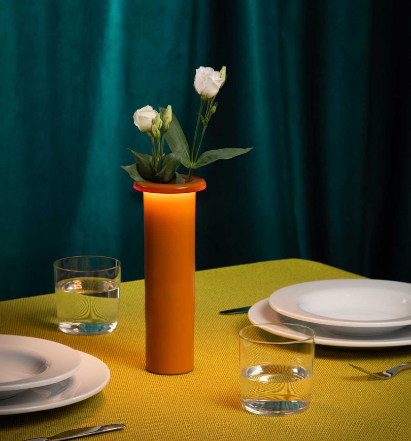 orange rechargeable lamp vase on dining table