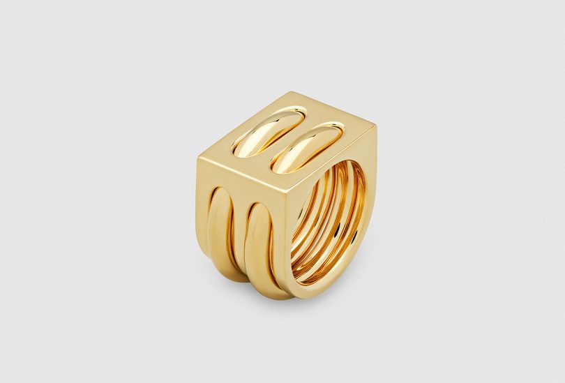 stacked gold rings on light grey background