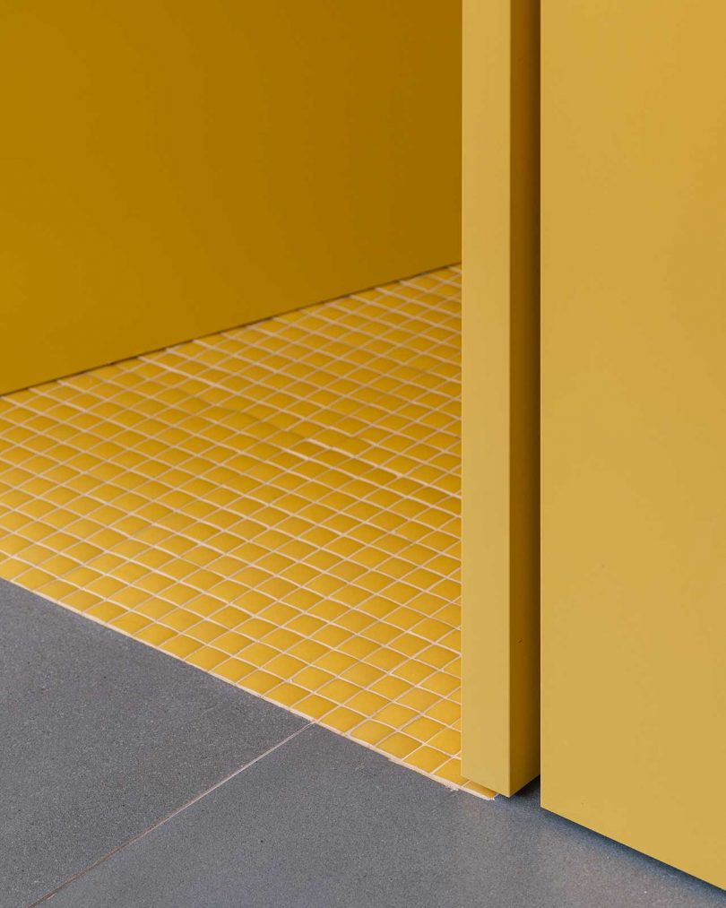 closeup floor shot of grey tile meeting yellow tile