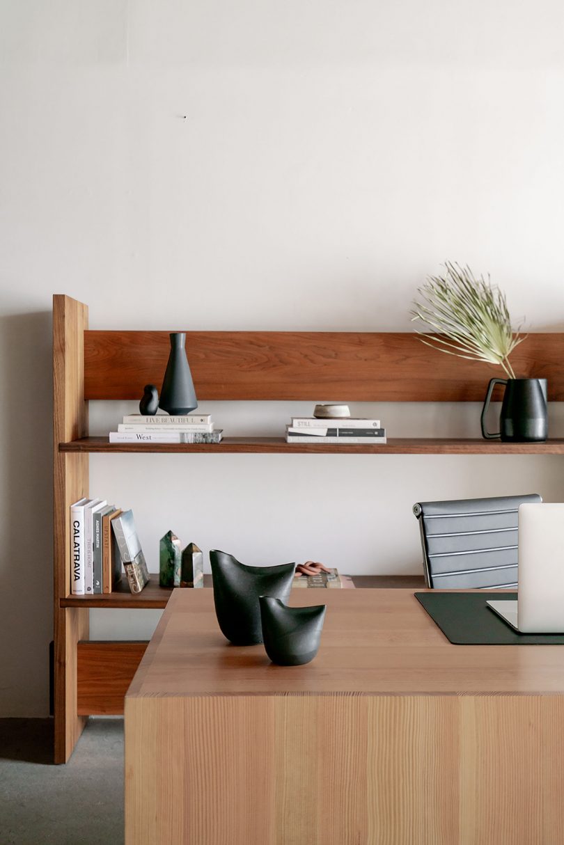 styled minimal light wood desk and medium wood shelving