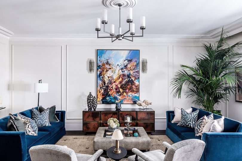 styled interior space with seating, coffee table, credenza, wall art, and chandelier