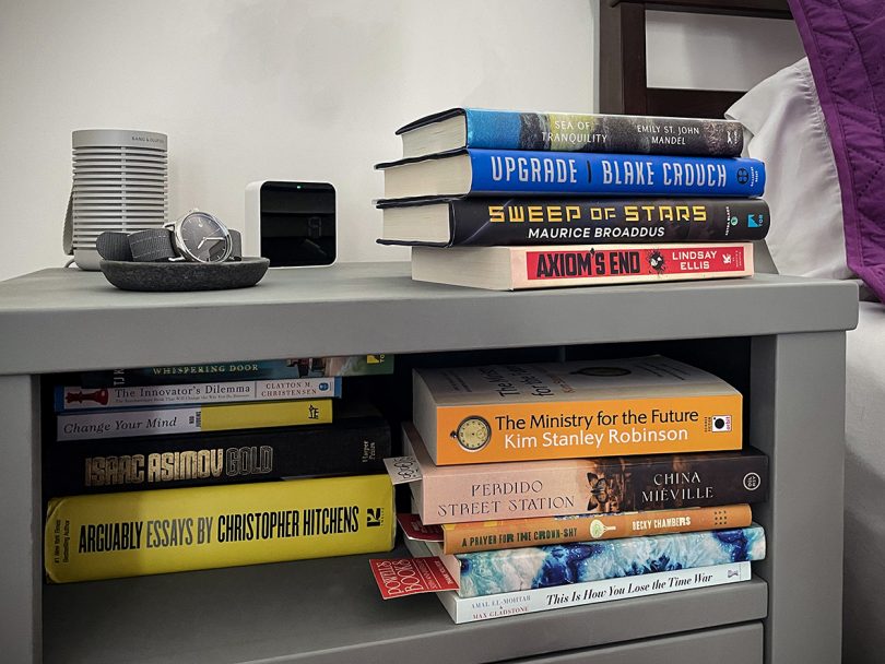 bedside table with stacks of books