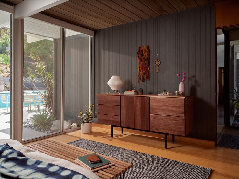 long and low dark wood dresser in styled interior space