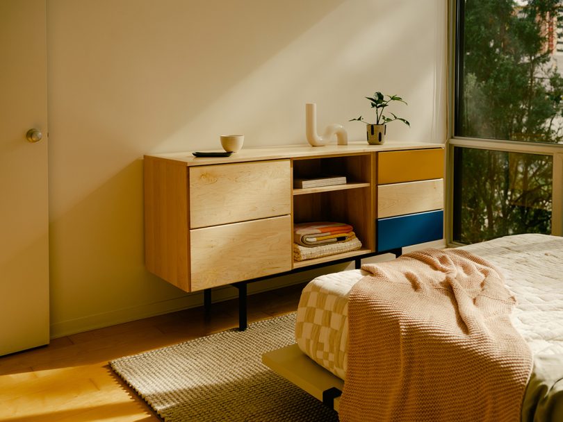 long and low light wood dresser in styled bedroom
