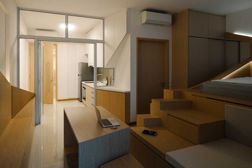night time view of small apartment interior with a multifunctional structure housing bed and storage