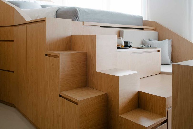 small apartment interior with a multifunctional structure housing bed and storage