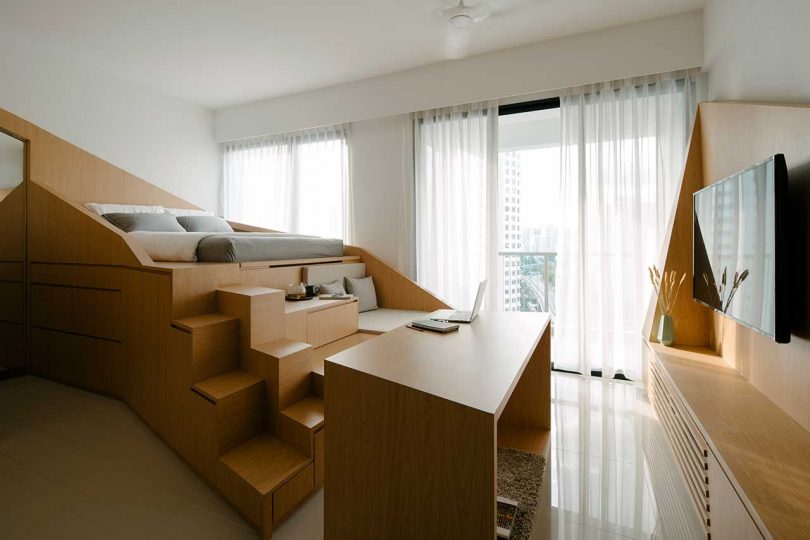 small apartment interior with a multifunctional structure housing bed and storage