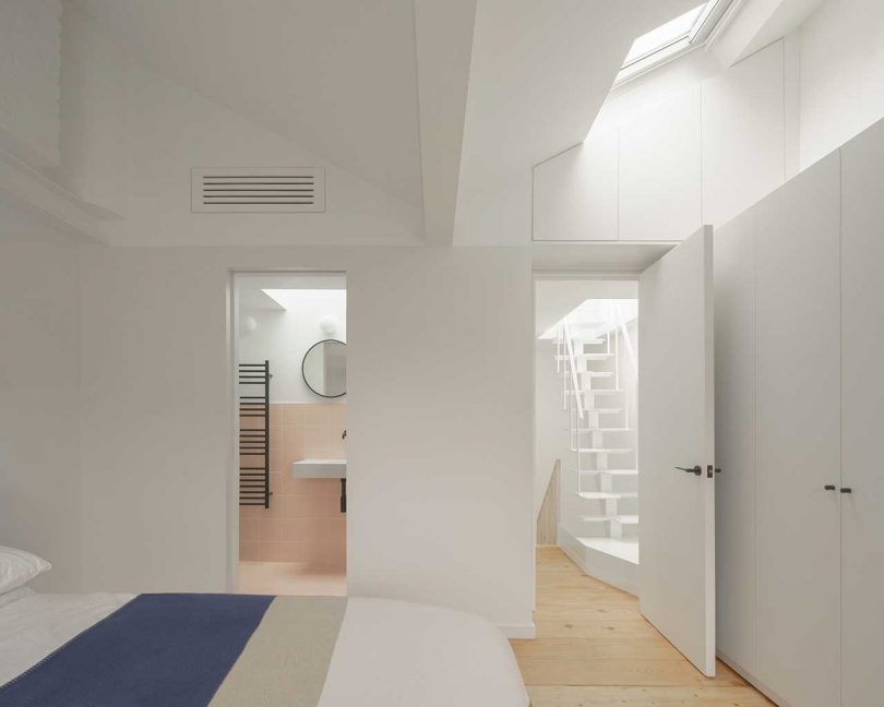 vista interior do quarto moderno com vista para banheiro e escada branca