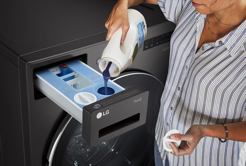 person pouring laundry detergent into a washing machine