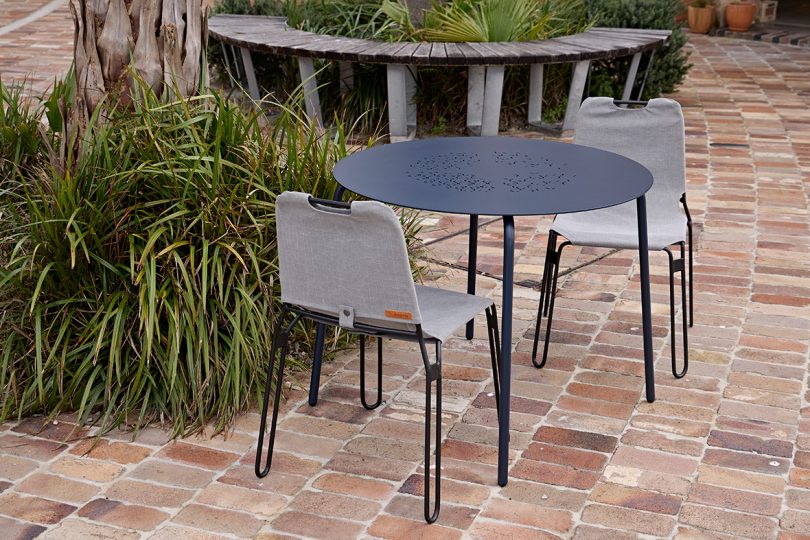 black metal outdoor table and chair, chair is covered in grey canvas