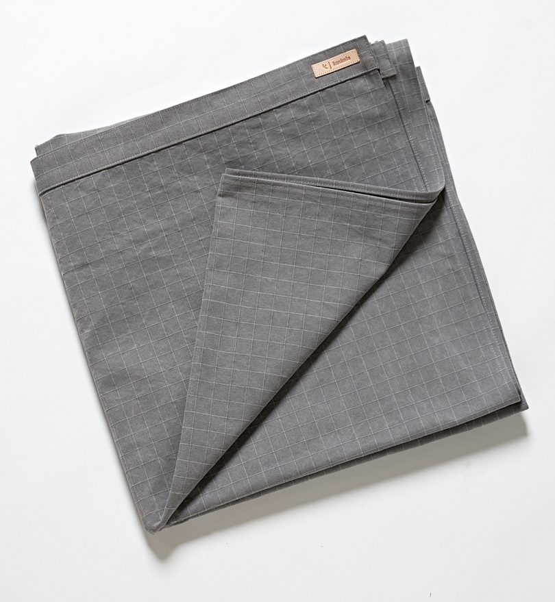 folded swath of grey canvas material on white background