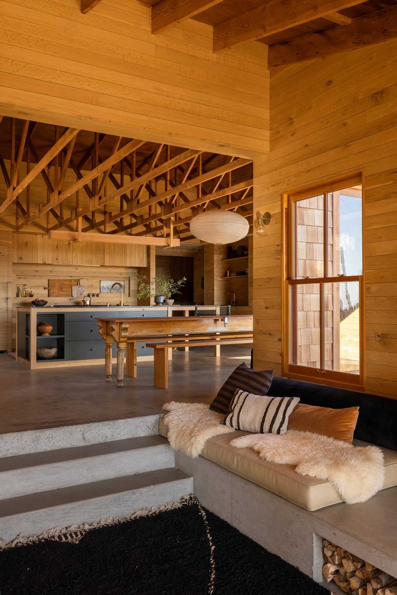 interior view from step down living room in modern mountain house looking to wood kitchen