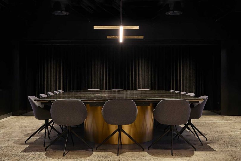dark dramatic conference room of office with black walls and dark furnishings