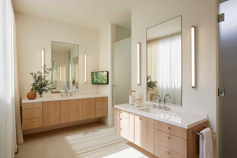 modern neutral bathroom with two wood vanities