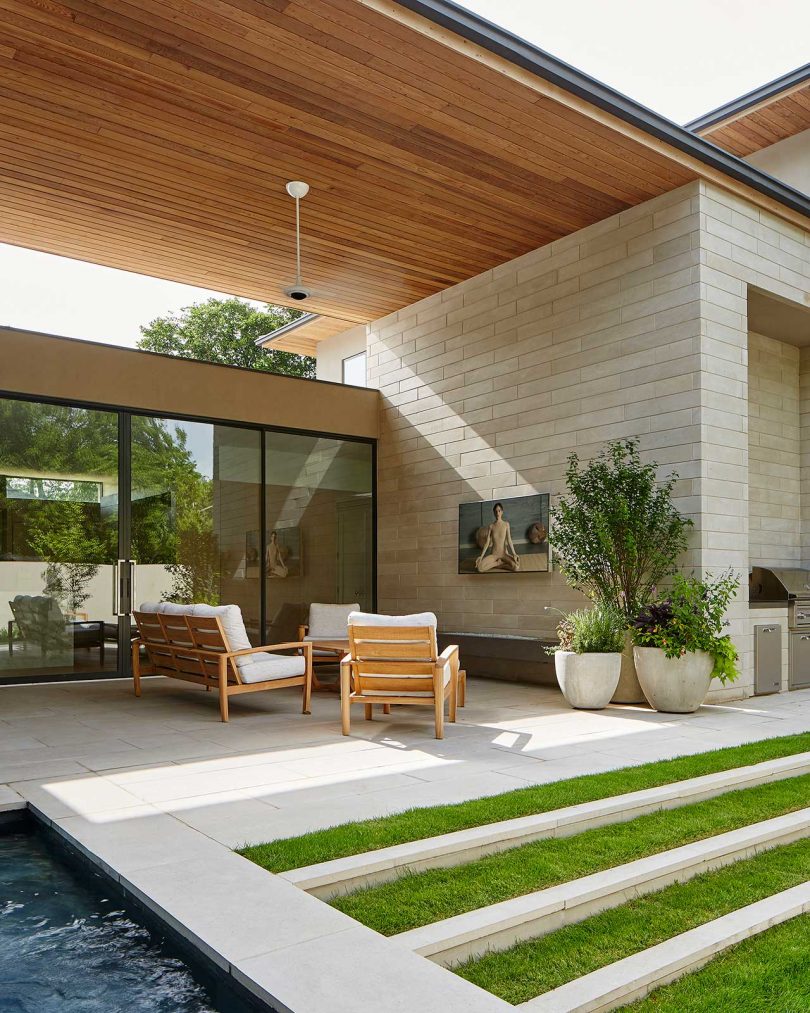 exterior rear view of modern house looking from yard to home's covered back patio