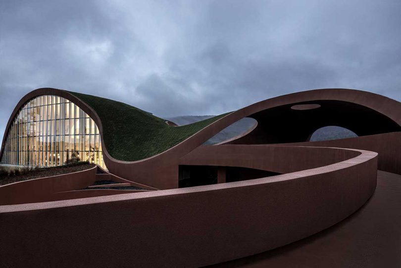 exterior shot of hot springs restaurant with undulating roof line and wall of windows
