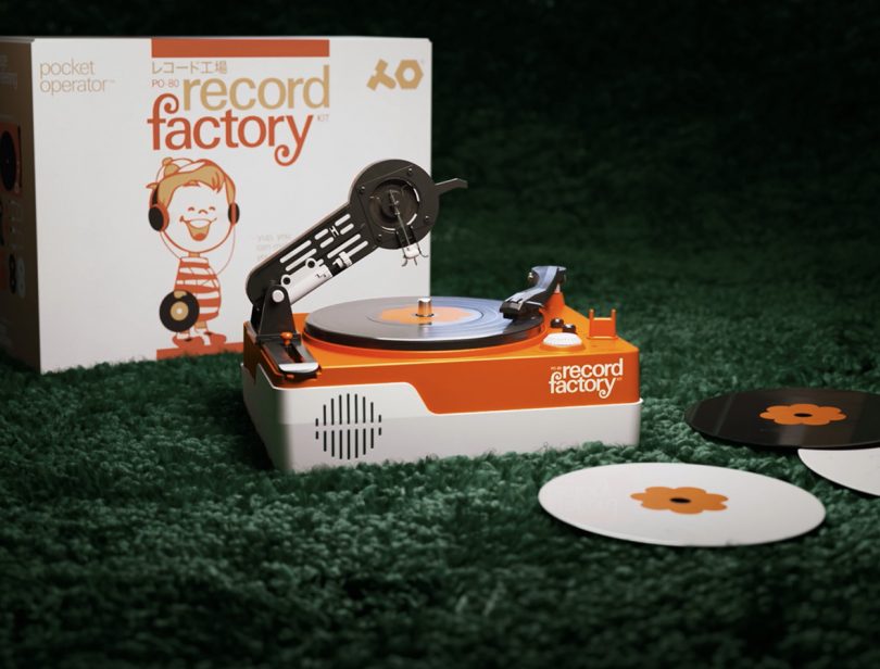 Small orange and white plastic turntable set on faux grass.