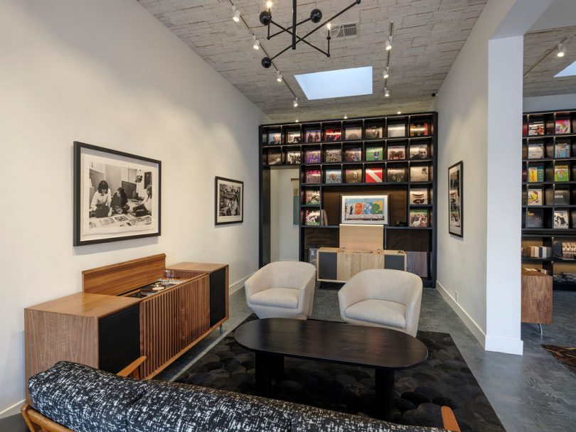 showroom interior with modern seating and stereo console and wall shelf of records