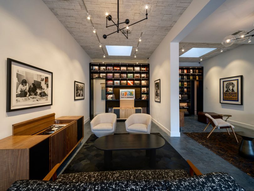 showroom interior with modern seating and stereo console and wall shelf of records