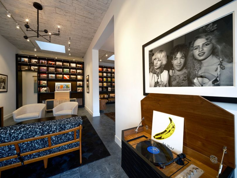 showroom interior with modern seating and stereo console and wall shelf of records