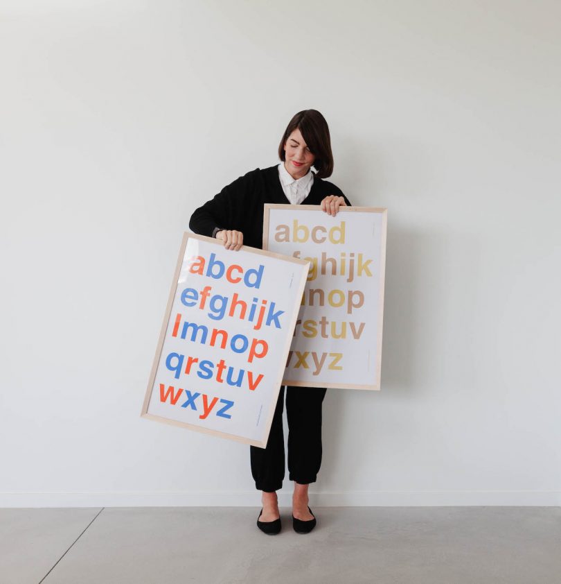 woman holding alphabet posters