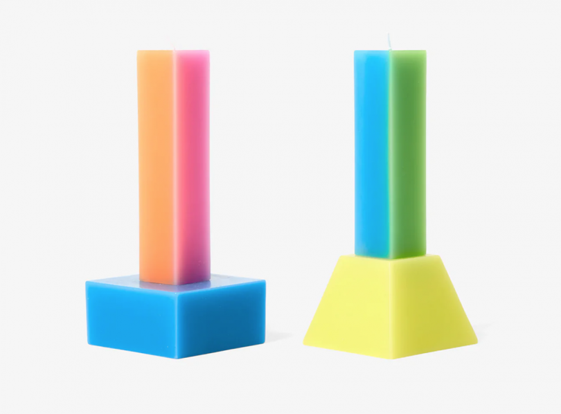 two colorful geometric pillar candles on white background