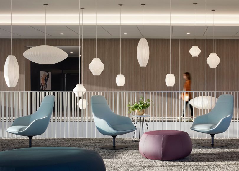 modern medical waiting area with several swivel chairs, end tables, and suspended lighting