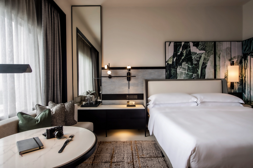 high design hotel room with bed, nightstand, and round table