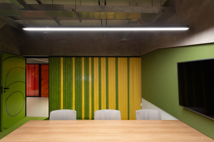 meeting space with conference table, chairs, and a green and yellow privacy curtain