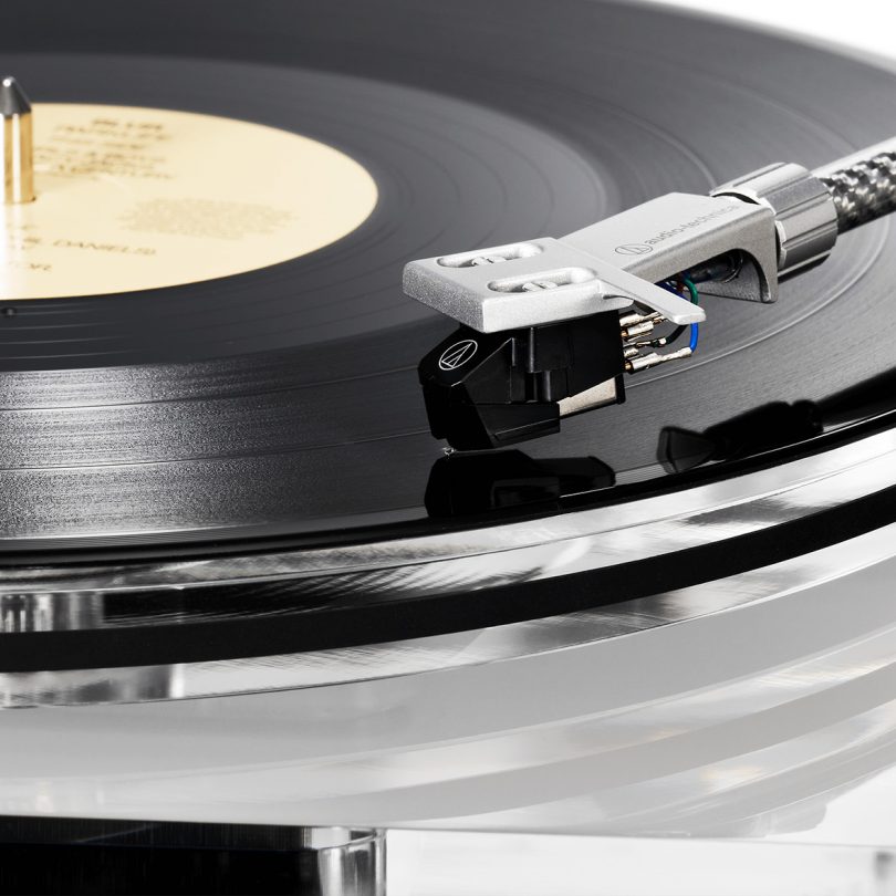 Cropped close-up view of clear-body Shibata stylus playing vinyl record.