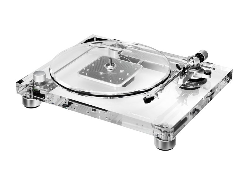 Three-quarter angled view of clear Audio-Technica turntable against white background.