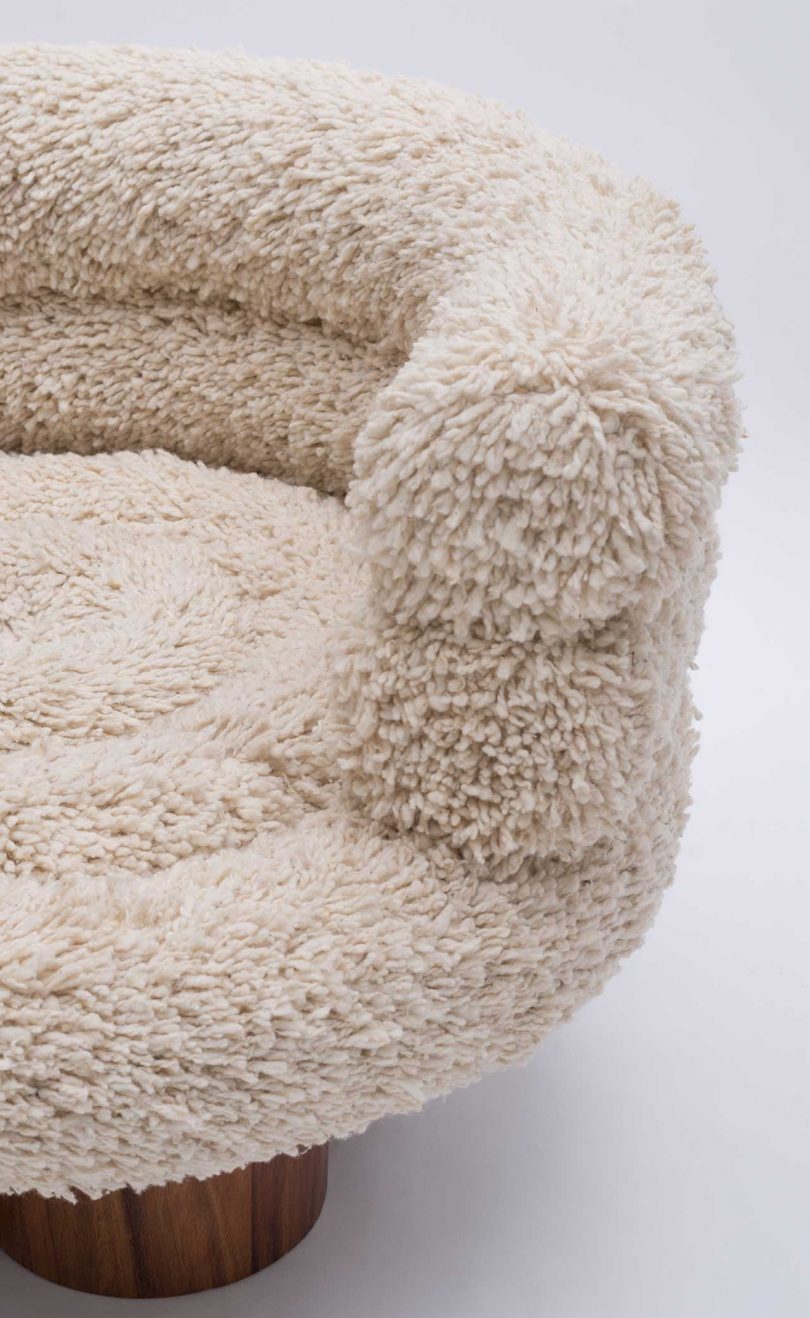 detail of boucle armchair with wood base